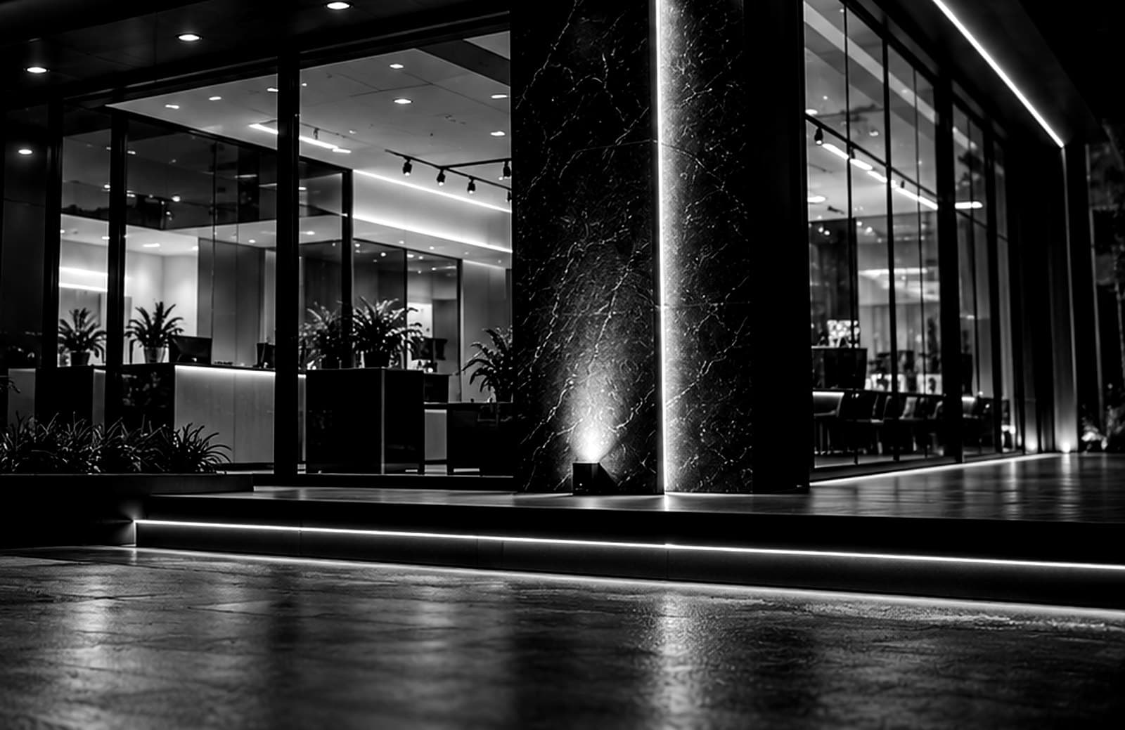 Entrada de fachada comercial com vitrine iluminada, em preto e branco